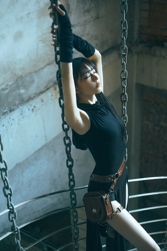 一位穿着黑色连衣裙的年轻女子 holding a chain