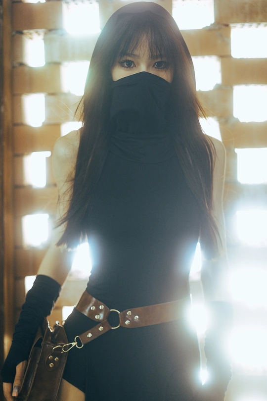 戴黑色口罩遮住脸部 用黑色皮带和手套包裹的手的女人