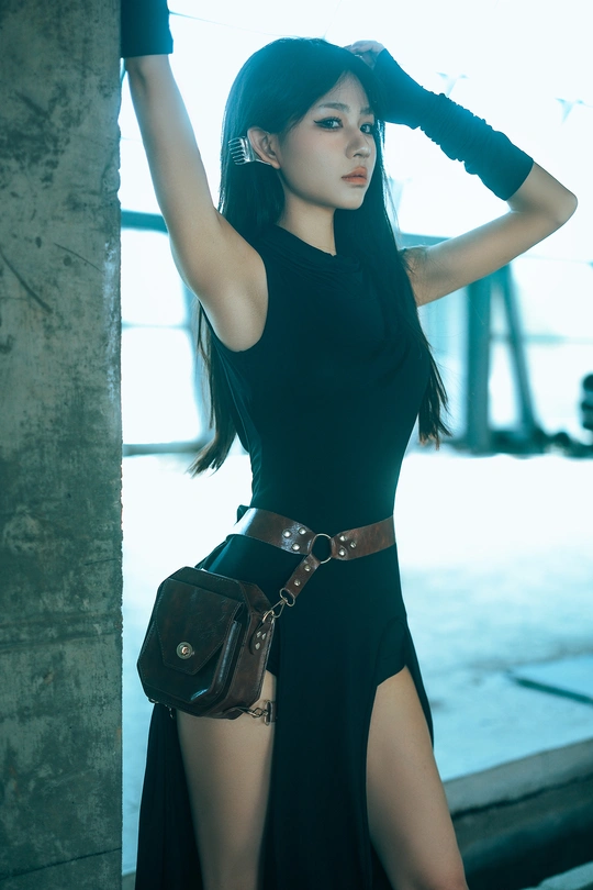 一个穿着黑色连衣裙的年轻女子站在一座废弃的建筑中