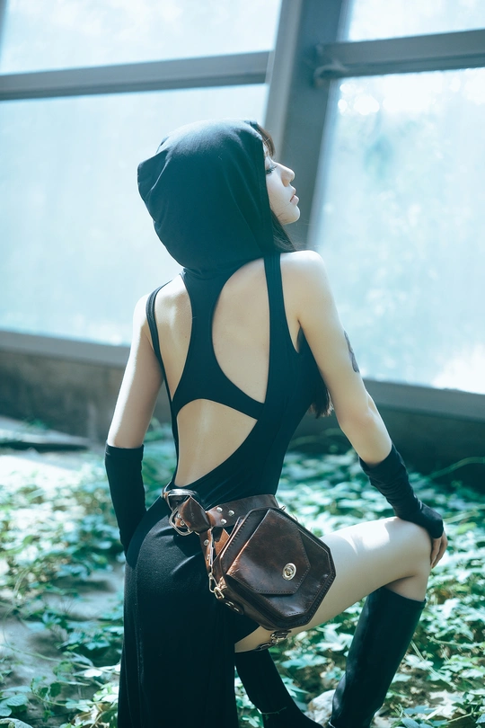 一个穿着黑色连衣裙的女人坐在那里 带着一个钱包。