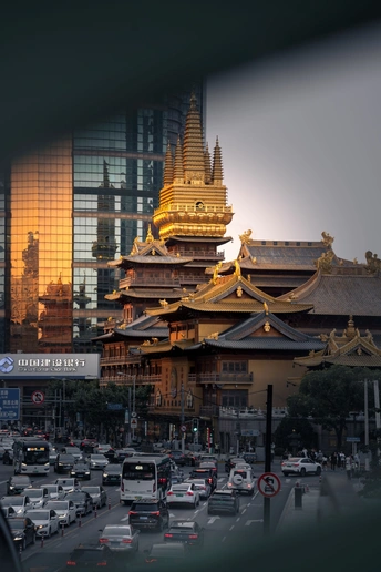 一条街道上有汽车和一座位于街道中央的大佛塔。