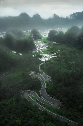 a winding road through a valley with mountains in 