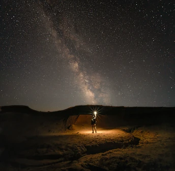 一个人站在沙漠中 星空在天上。