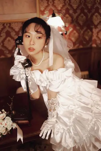 一位穿着白色婚纱和戴着手套的女人正在打电话
