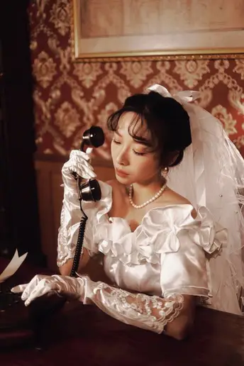 一个穿着白色婚纱的女人正在打电话