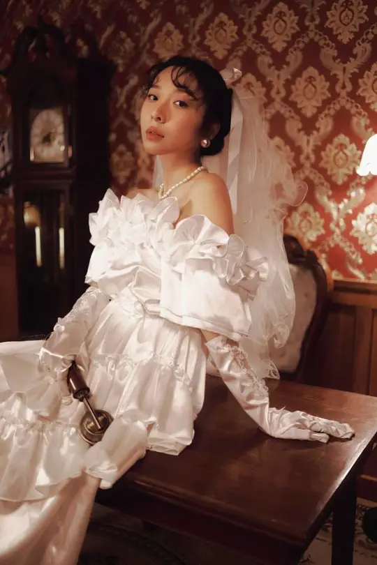 一位穿着白色婚纱的女人坐在桌子旁