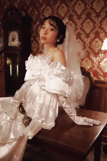 一位穿着白色婚纱的女人坐在桌子旁