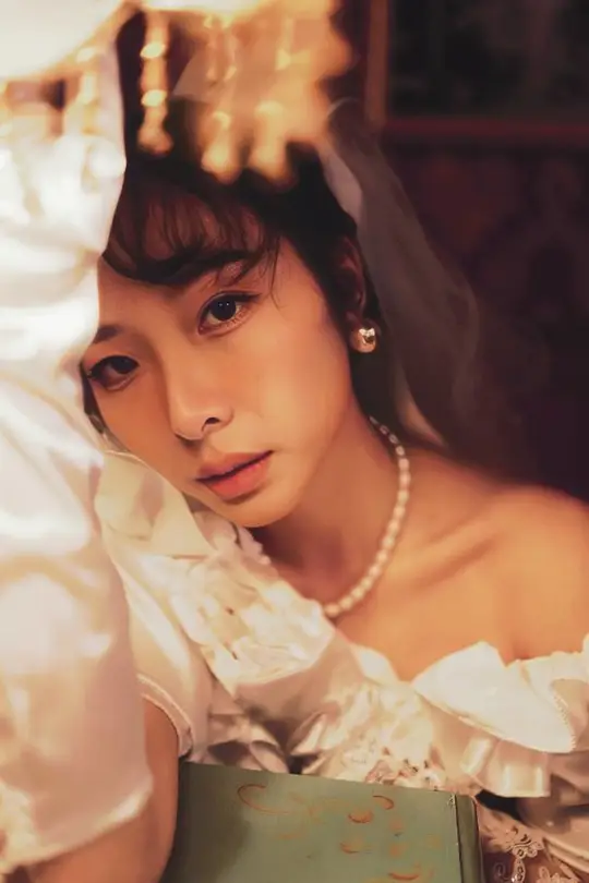 一位穿着白色婚纱的年轻女子带着一本书