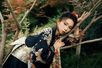 一位穿着和服的女子在树树枝间摆姿势