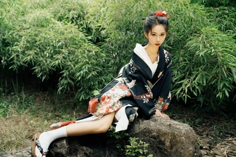 一位身着日本传统和服的年轻女子坐在岩石上
