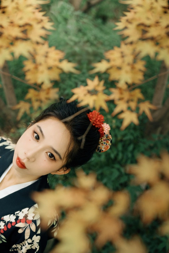 一位穿着红白相间浴袍的年轻女子在森林中为肖像摆姿势