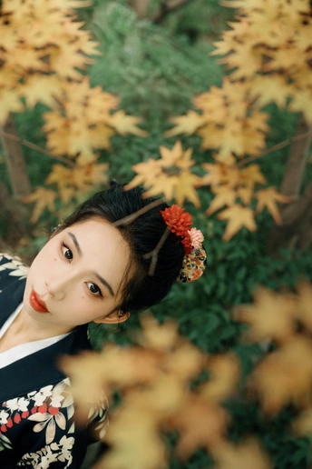 一位穿着红白相间浴袍的年轻女子在森林中为肖像摆姿势