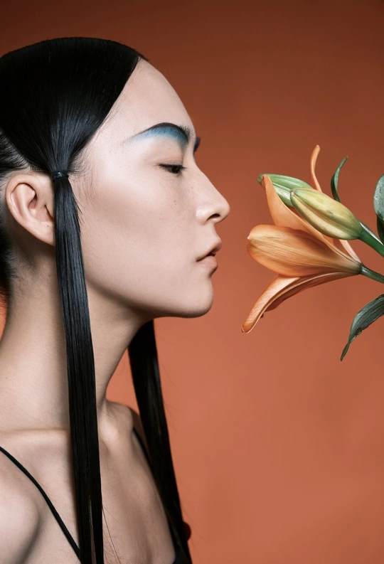 一位长着蓝眼睛、长发飘飘的年轻女子抱着花。