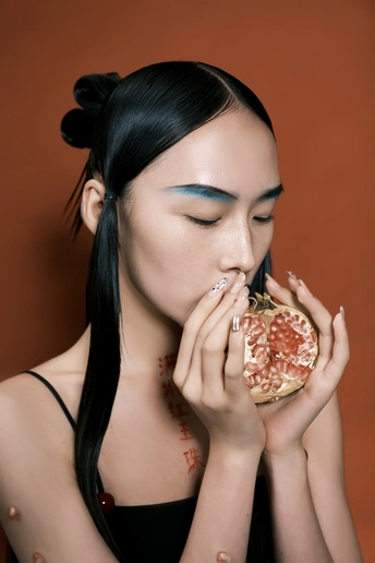 一位美丽的年轻女子 眼睛蓝色 化着黑色妆容 手里拿着披萨。