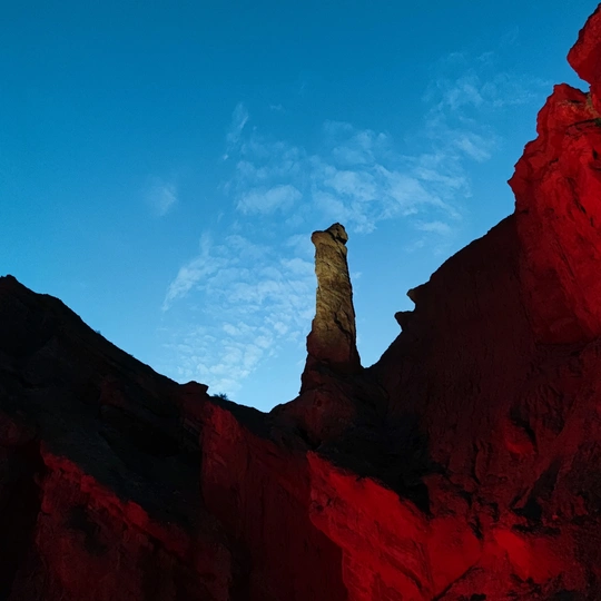 红色岩石的塔在蓝色的天空中被阳光照亮