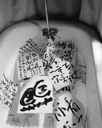 一个带有脏厕所和墙上写有黑色字迹的白瓷洗脸盆的浴室