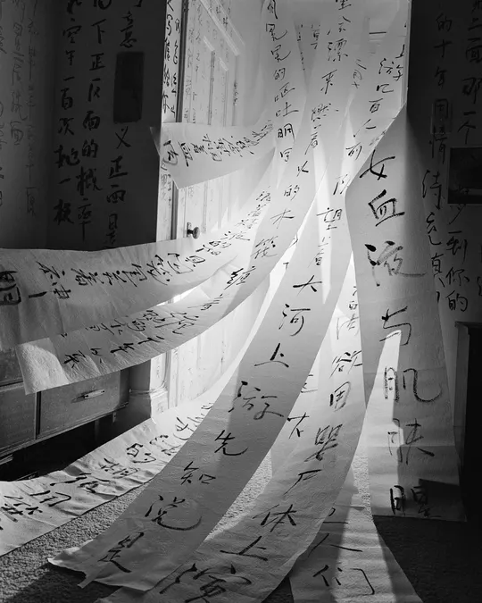 一个带有床、窗帘和上面覆盖着有中文书写的纸张的墙壁的房间。