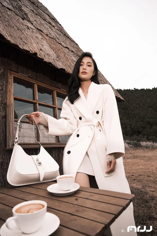 一位穿着白大褂的女性 桌子上放着一杯咖啡。