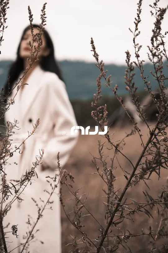 一位穿着白大褂的女士站在田野中