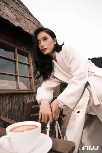 一位穿着白大褂的美女在咖啡馆里举着一杯咖啡