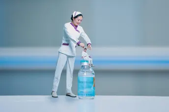 一个人站在一个塑料水瓶旁边的一张桌子旁边