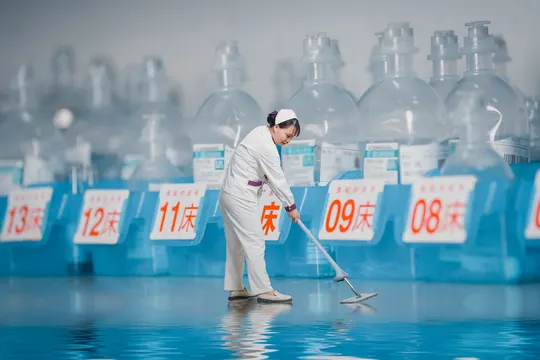 一位穿着西装的男子正在打扫房间的地板。
