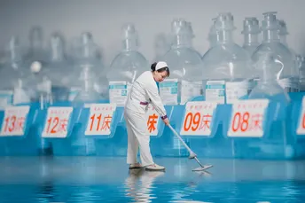 一位穿着西装的男子正在打扫房间的地板。
