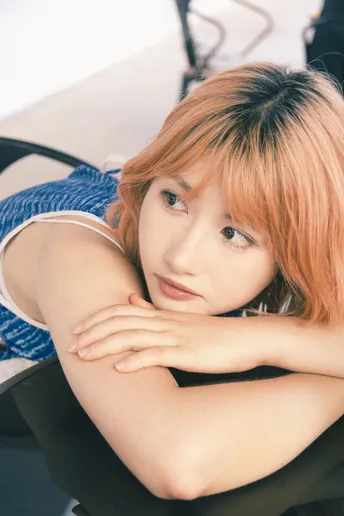 一位红发年轻女子坐在黑色椅子上