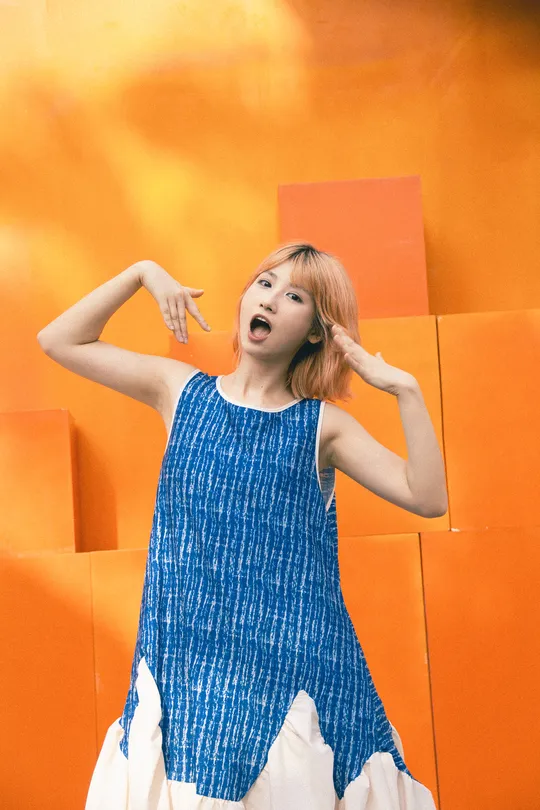 一位穿着蓝白色连衣裙的年轻女子正在用剪刀摆姿势