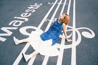 一位穿着蓝色连衣裙的年轻女子穿过马路