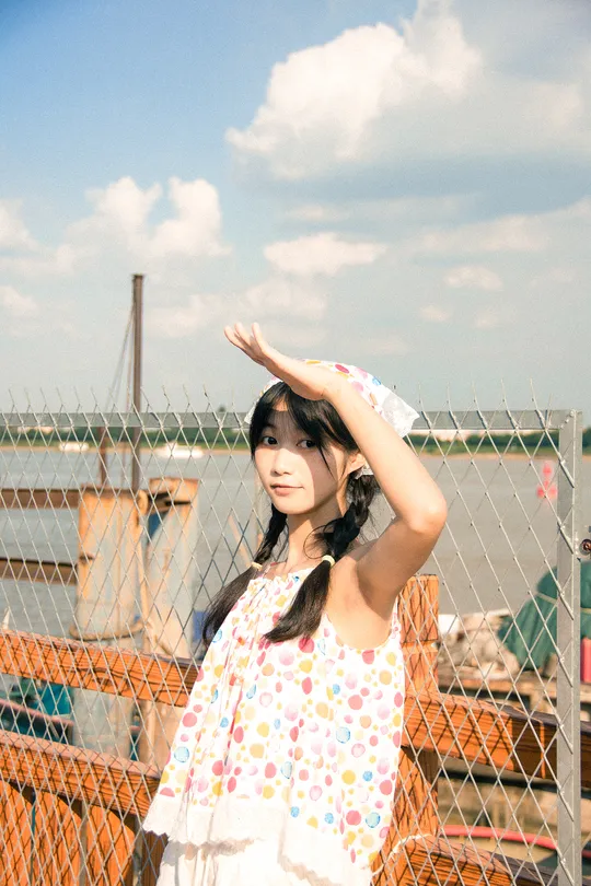 一个穿着连衣裙的小女孩双手背后 做出姿势