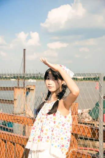 一个穿着连衣裙的小女孩双手背后 做出姿势