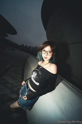 一位留着蓝色头发的年轻女子站在屋顶上