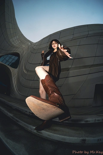 一位女性站在滑板上 双腿交叉在建筑物前拍照。