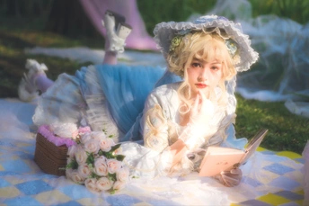 一位穿着白色连衣裙的年轻女子正在一块蓝色和白色格子毛毯上阅读一本书。