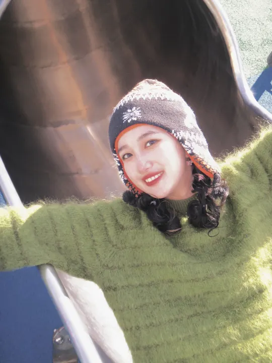 微笑的年轻女子穿着一件绿色毛衣