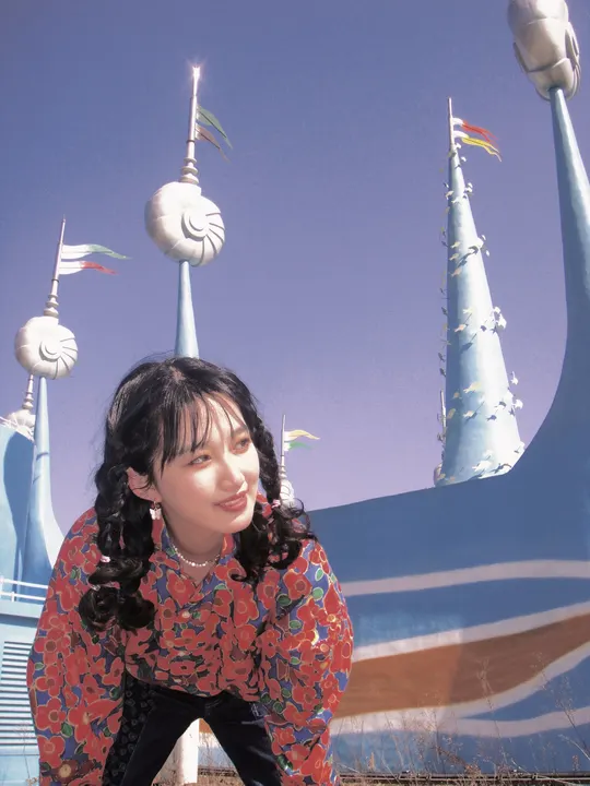 站在卡通主题公园前的年轻女子