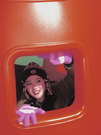 一个年轻的儿童正在窗口看着一只小猫