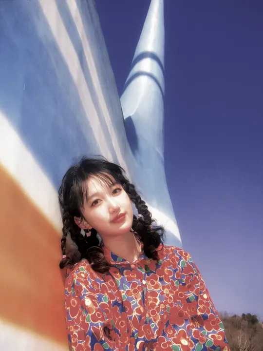 站在火箭前面的穿着连衣裙的年轻女子