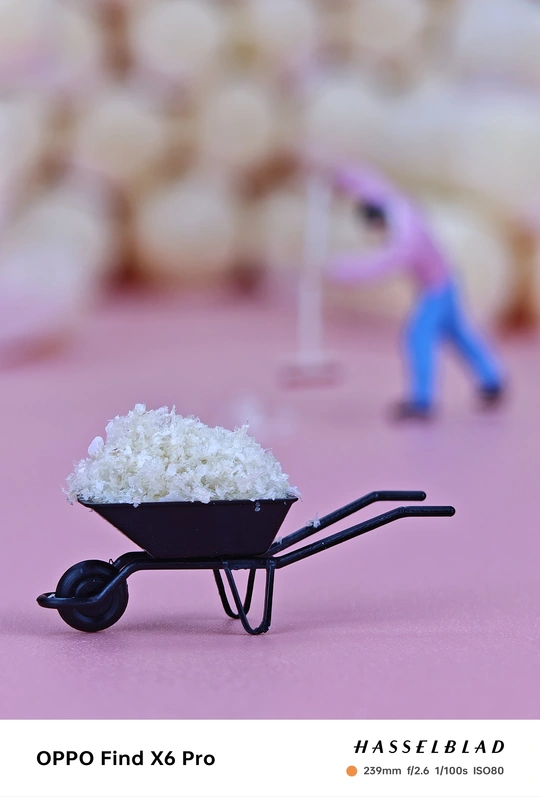 一个微型人物塑像 这个人物正在推一个装满米的独轮车。