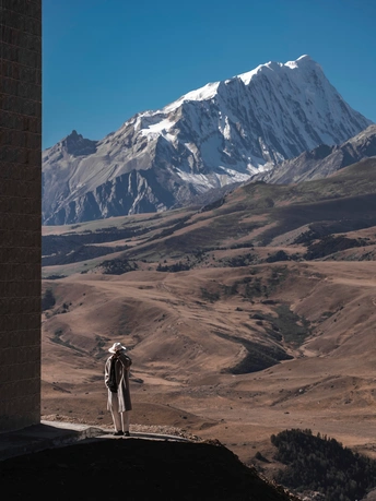 站在窗前向外看山脉的一个男人