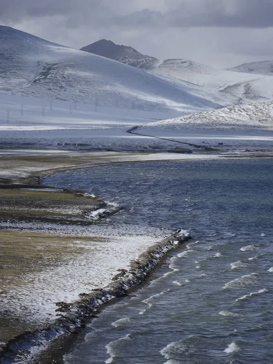雪景 山丘 山脉和前景流动的水体 冬季