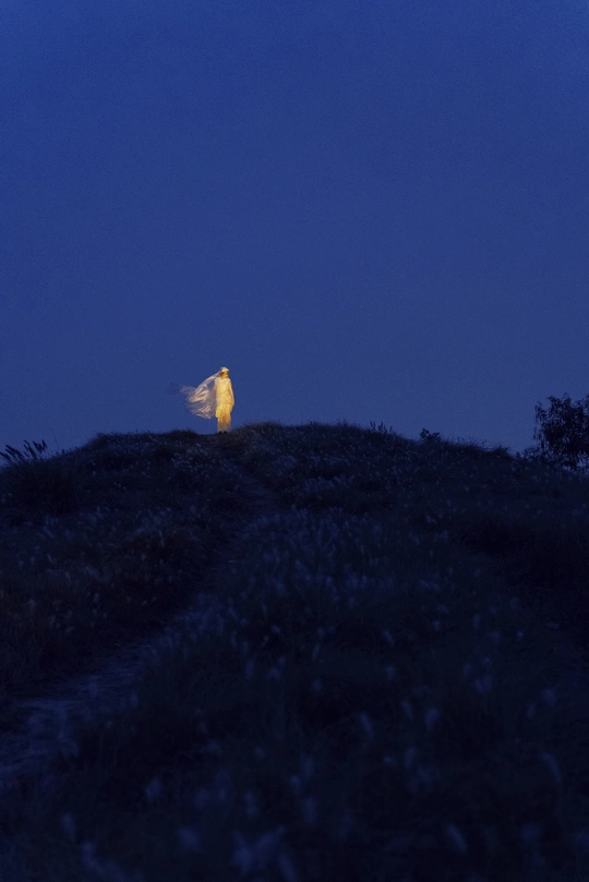 一个人站在山顶 满月和白色灯光