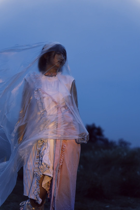 一个戴白色长裙和面纱的女子在月光下黑暗中行走