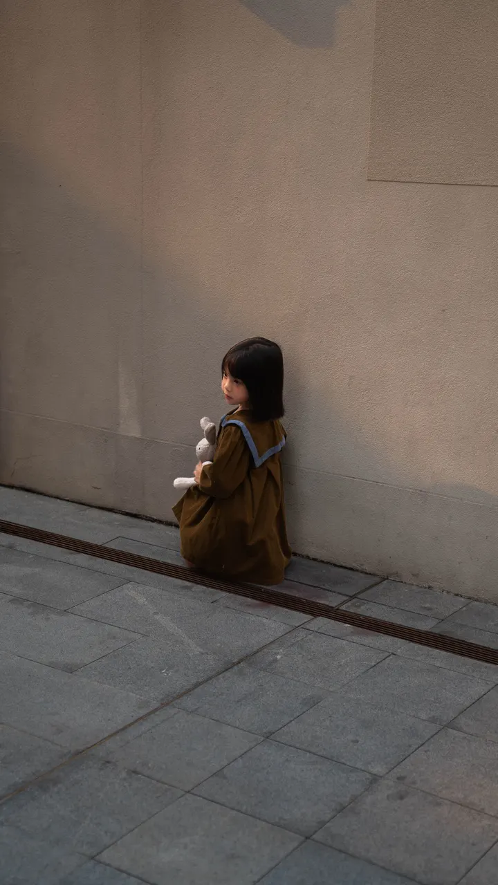 街边抱着兔子玩偶的小女孩