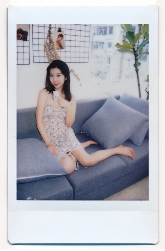 一个穿着连衣裙的年轻女子坐在客厅的蓝色沙发上