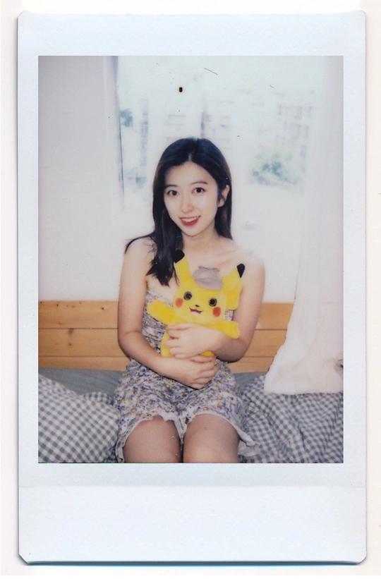 一个年轻女子抱着一只黄猫坐在床上