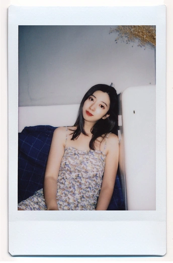 一位穿着连衣裙的女子躺在床上的一幅画