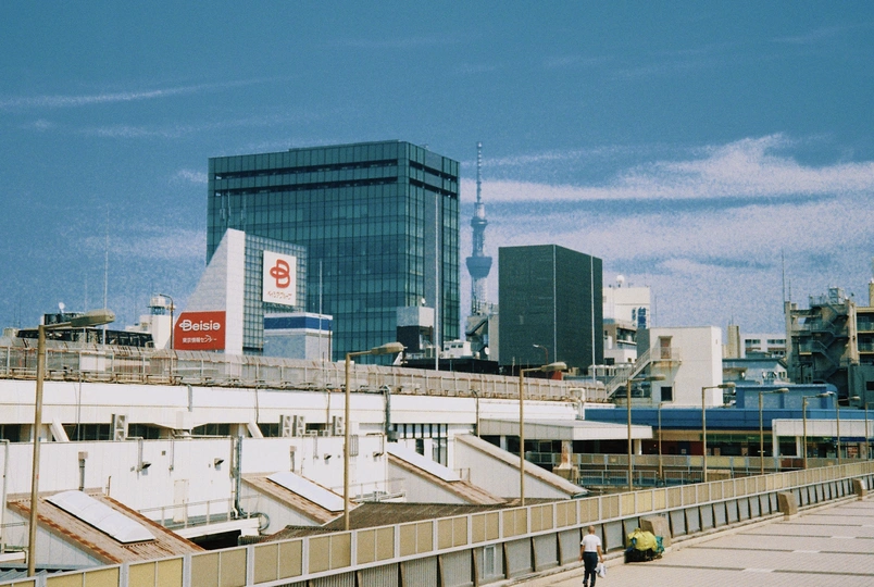 一个人在城市里骑滑板车 周围有高楼大厦。