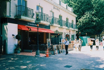 人行道上行人行走 街道两边是商店。